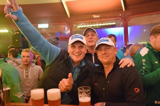 Drei Männer lachen in die Kamera und trinken Bier