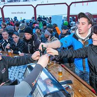 Wintersportler feiern im Freien und trinken Schnaps
